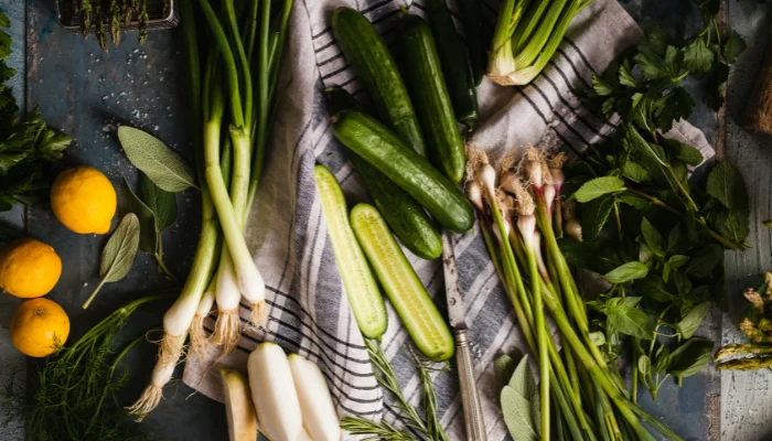 Lemons, cucumbers, and green onions on a kitchen table ready for use