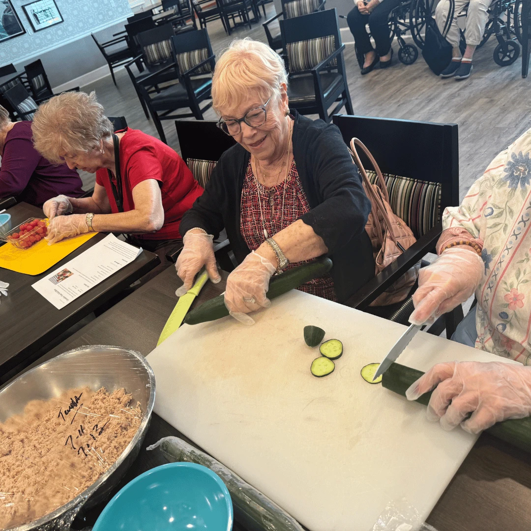 Residents at The Bristal at Wayne chop vegetables as a group to prepare a snack for all to enjoy.