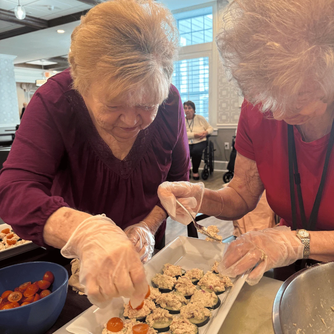 Working as a team, seniors at Wayne layer the ingredients in a tray for presentation.