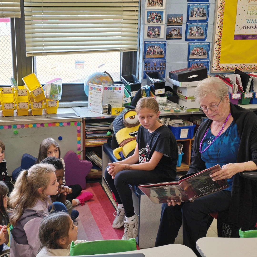 A senior resident reads a Halloween picture book to a group of students from Massapequa.