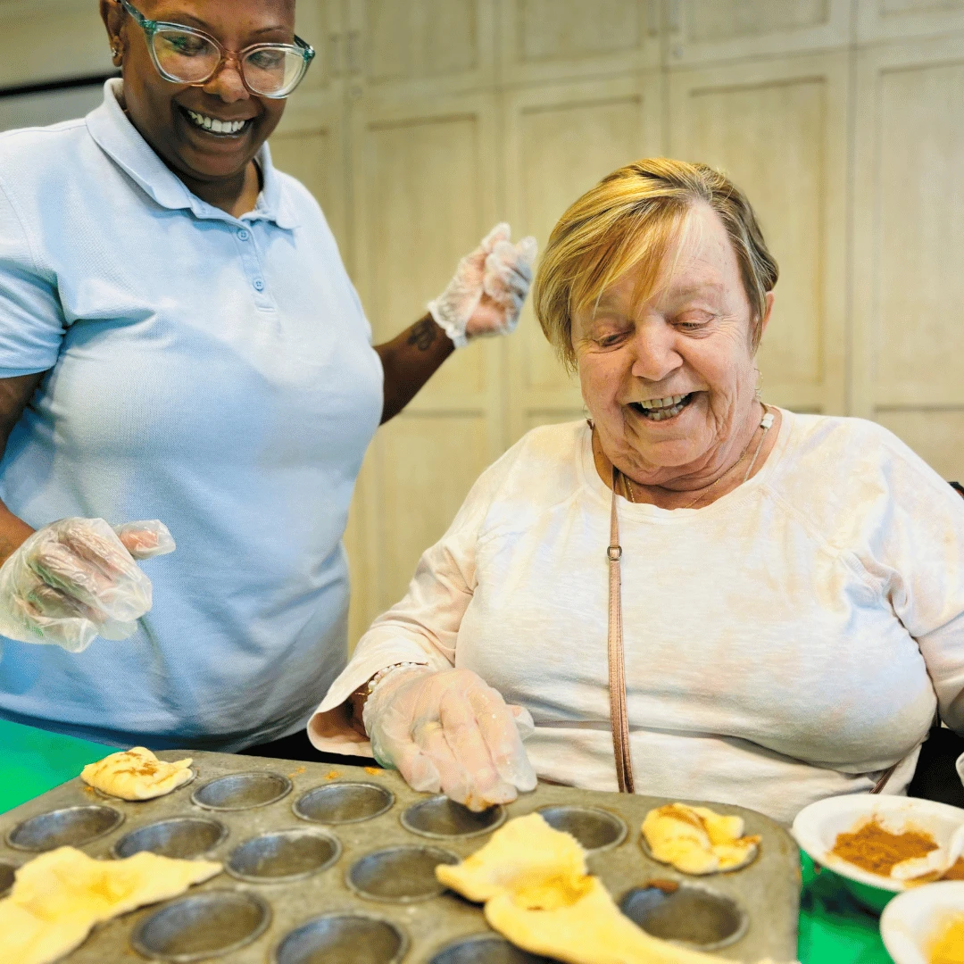 Senior and team member create apple pie bites together.