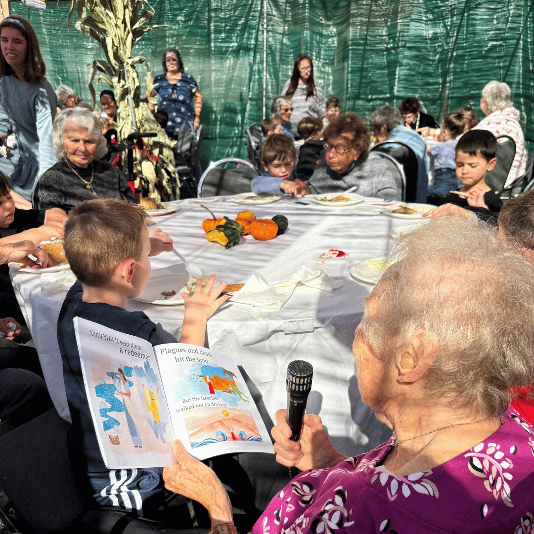 Resident of The Bristal at North Woodmere reads a story about Sukkot to the children of HERJC