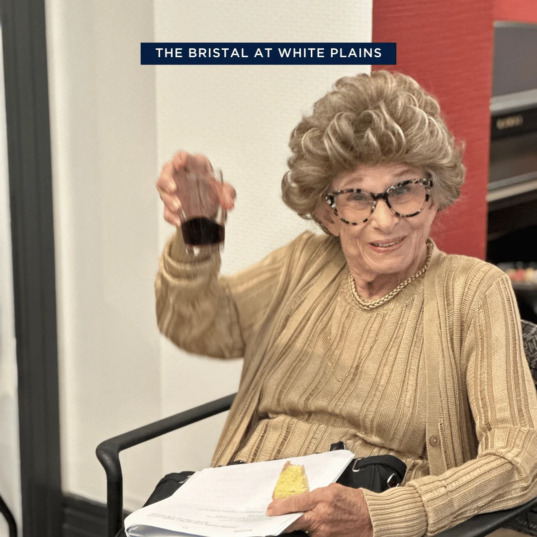 Resident at The Bristal Assisted Living at White Plains raises a glass in celebration of the Jewish New Year