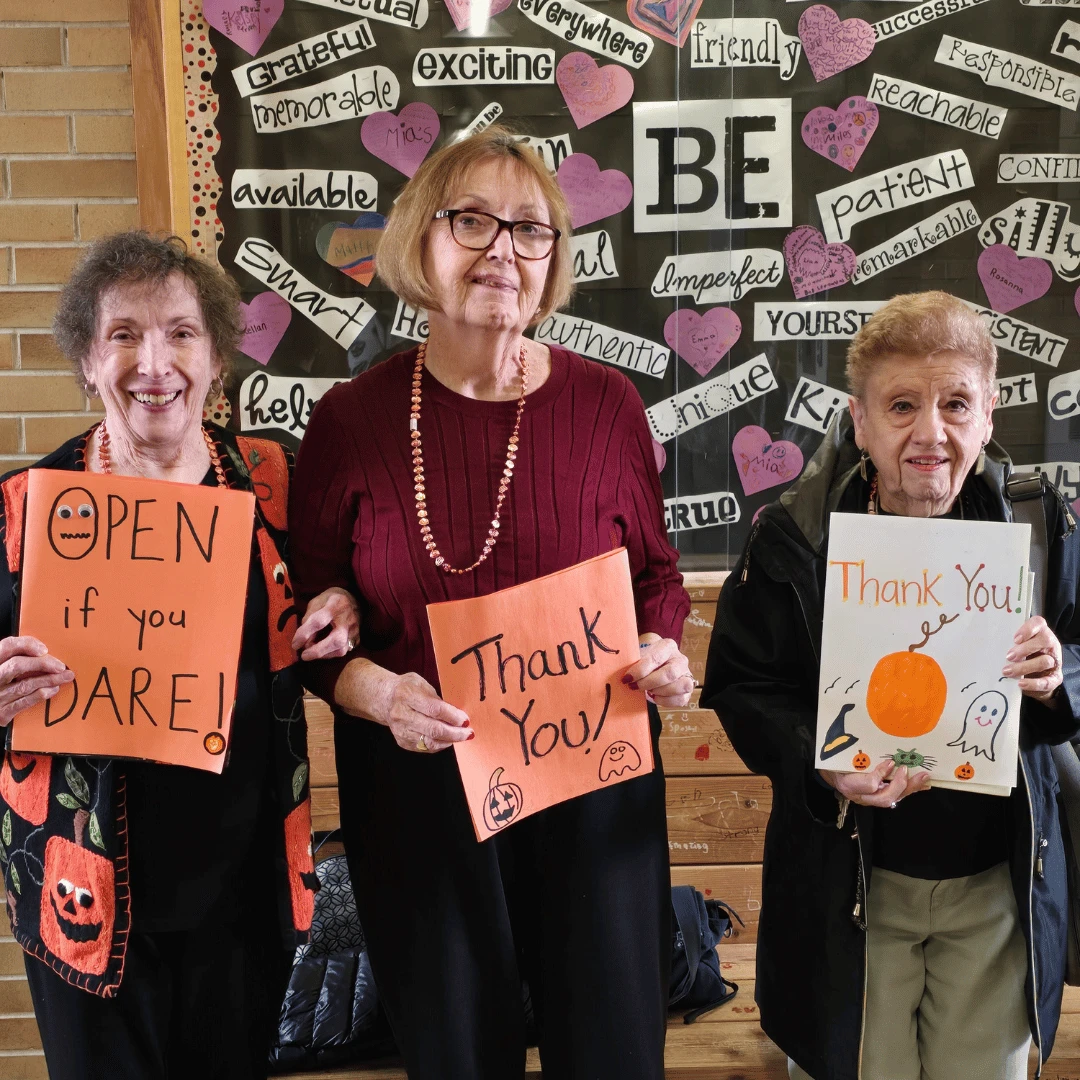 Massapequa residents hold Thank You cards created by the elementary students.