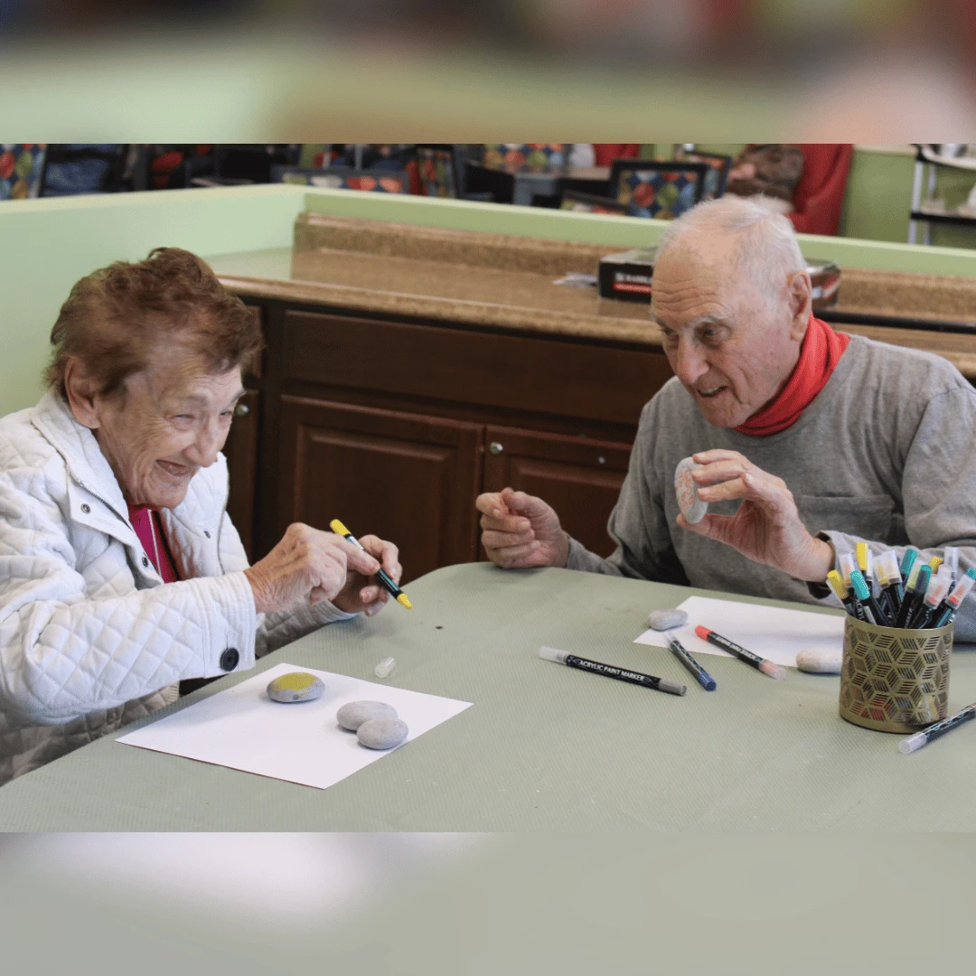 Two residents collaborate to create rocks for World Kindness Day at The Bristal Assisted Living at Lynbrook