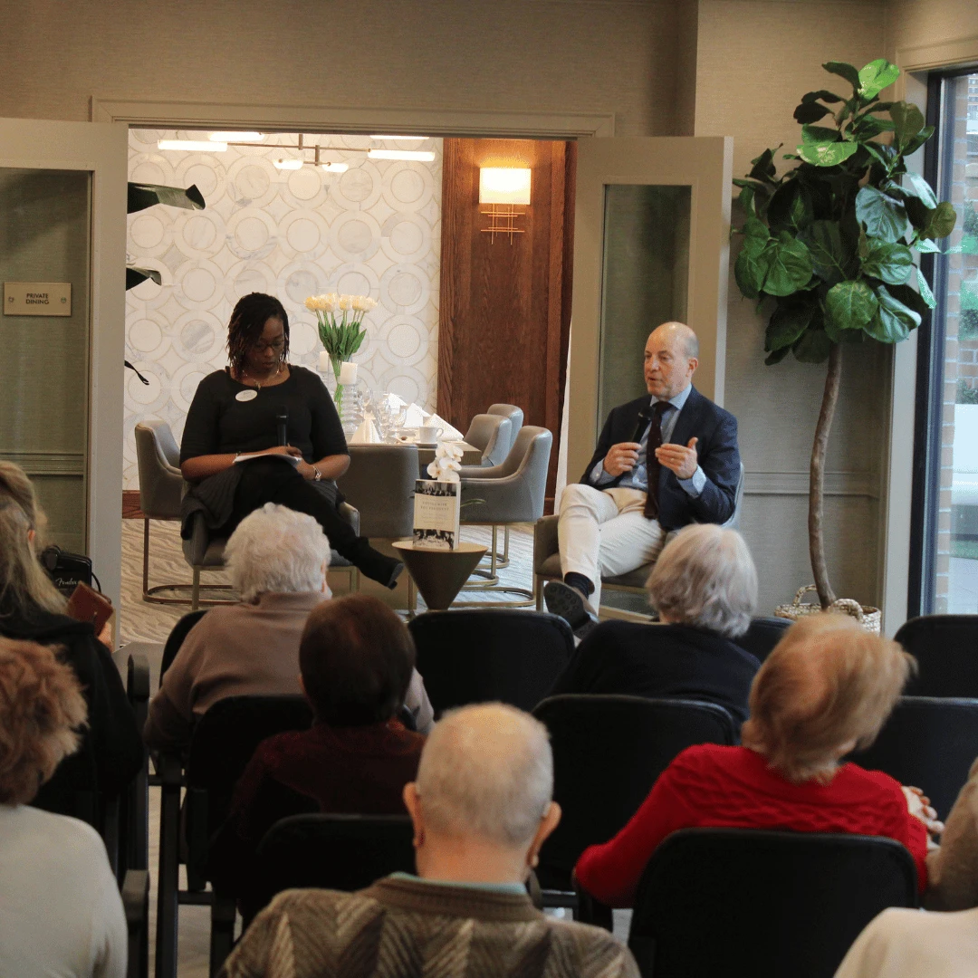 author and moderator on stage in front of residents of The Bristal at York Avenue in NYC