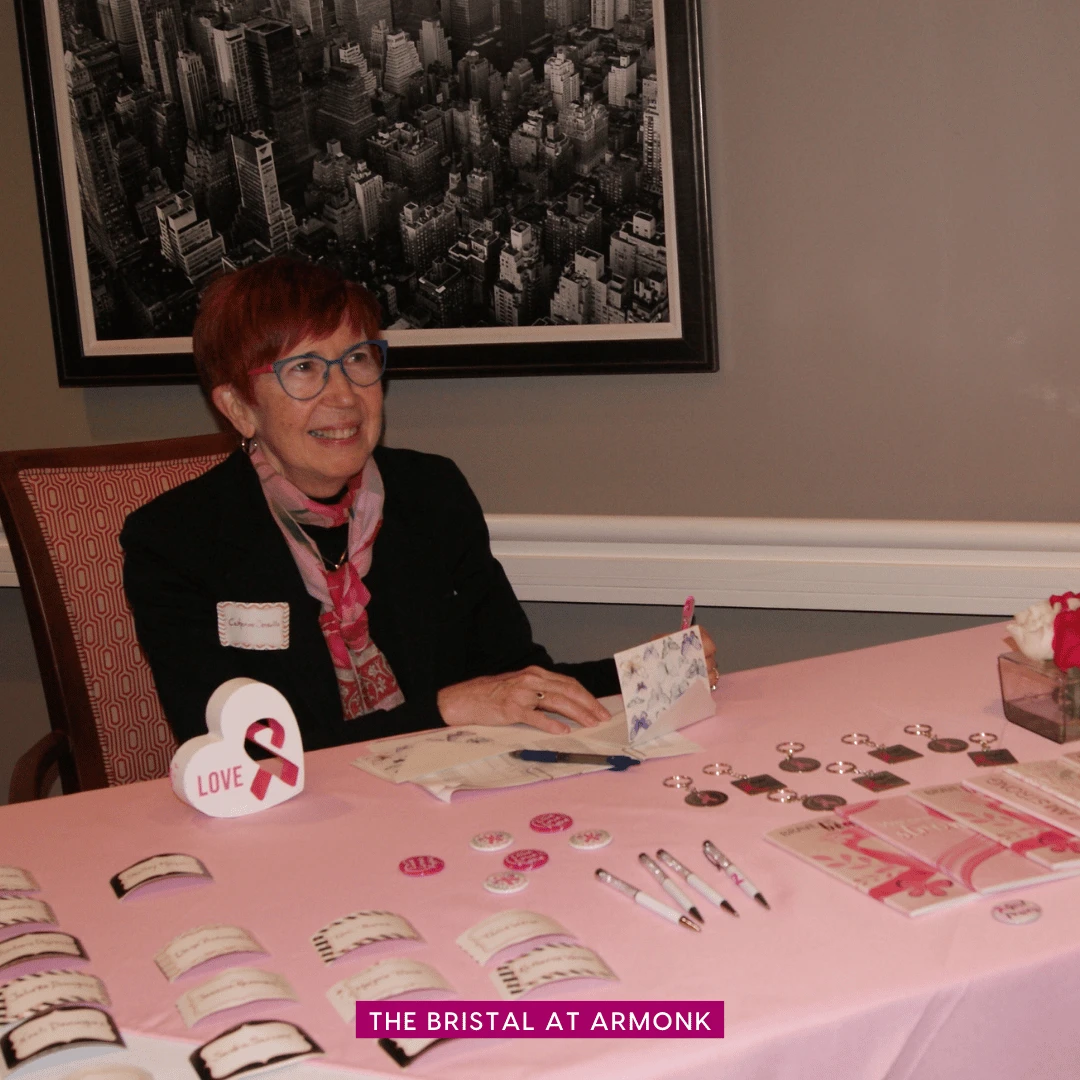 A woman sits behind a table at The Bristal at Armonk 
