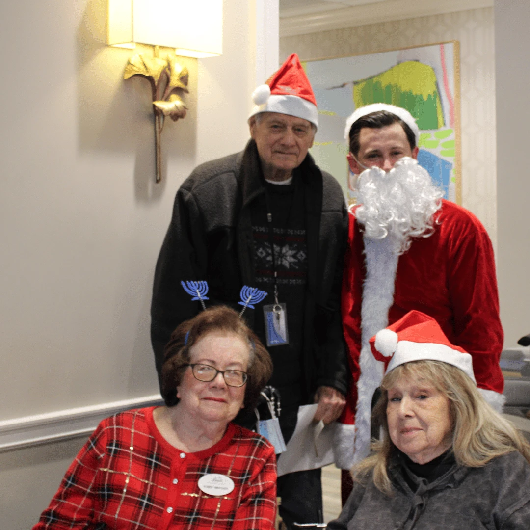 team member dressed as Santa Claus poses with residents at the tree lighting at The Bristal at Jericho