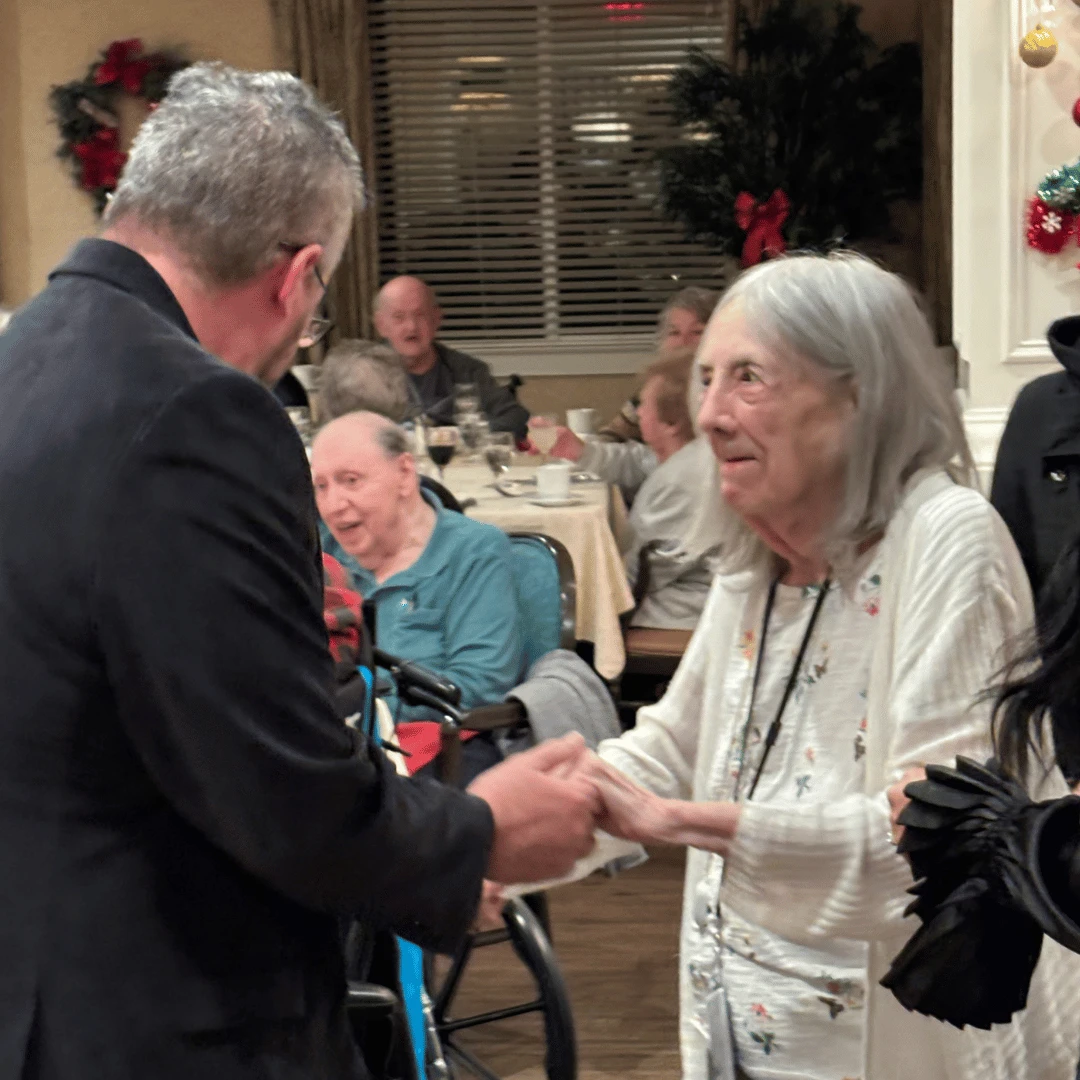 Two senior residents at Holtsville dance together during the holiday musical performance.