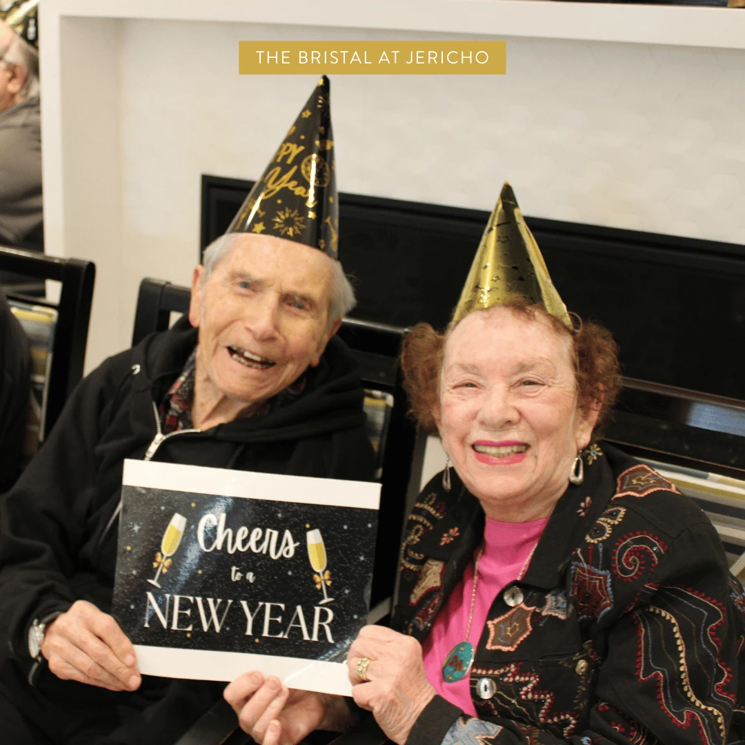 Two residents at The Bristal Assisted Living at Jericho wearing party hats to celebrate the new year