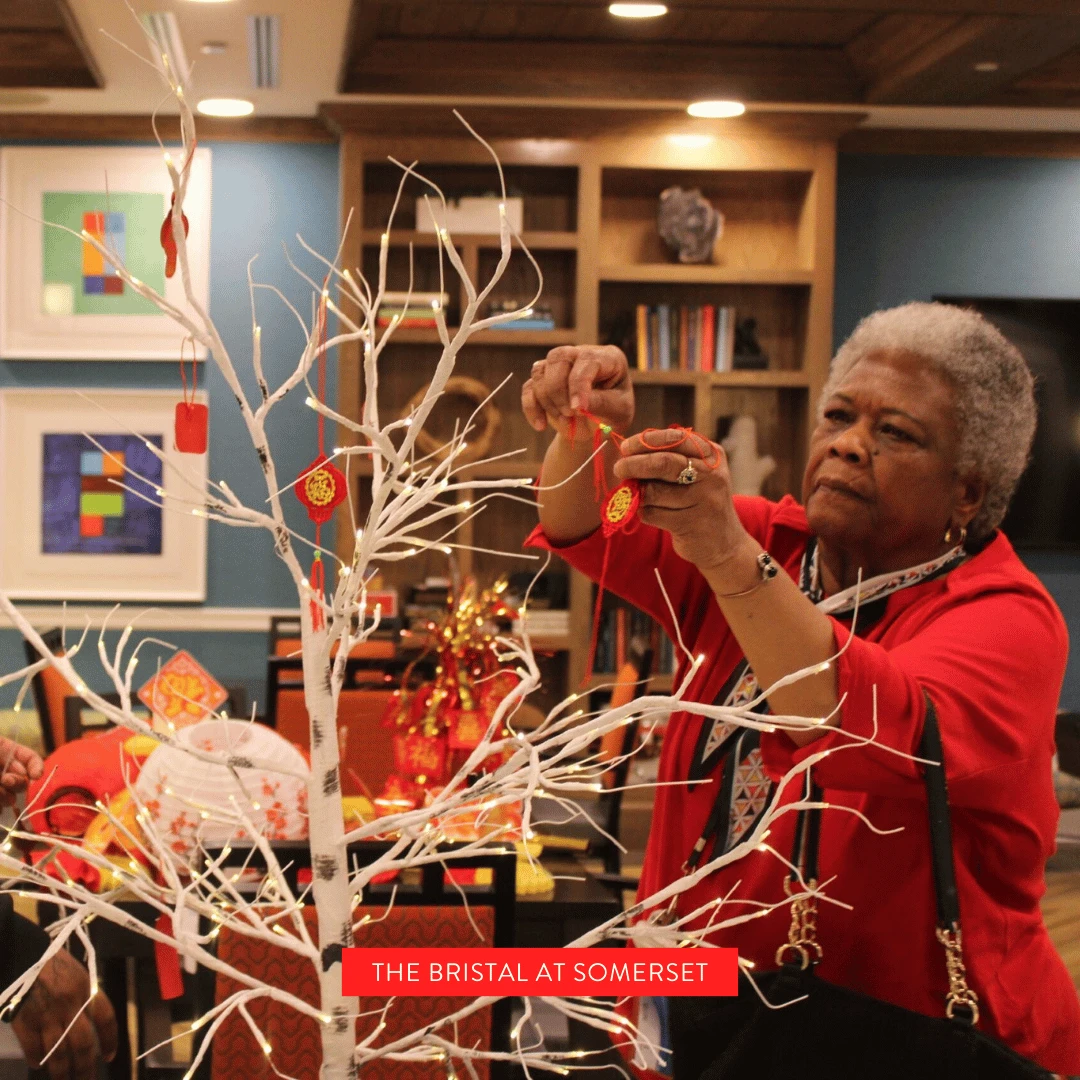 Somerset resident hangs decorations on a festive tree for Lunar New Year
