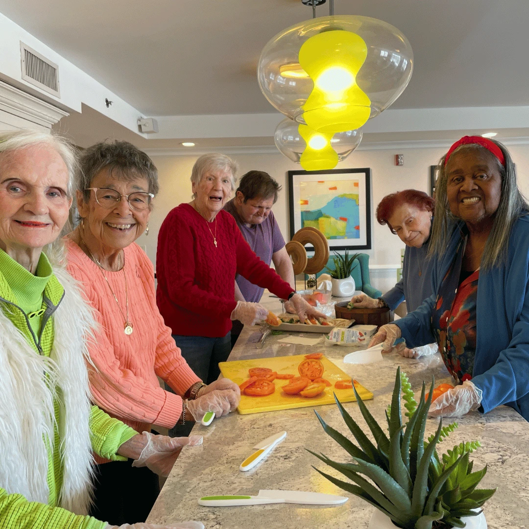 Residents sliced tomatoes and mozzerella and arranged them for a caprese salad.