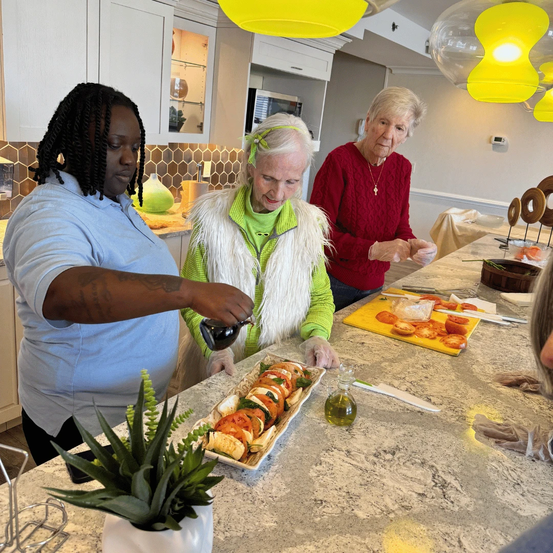 Team member adds the finishing touch to a resident-prepared salad at The Bristal at Westbury.