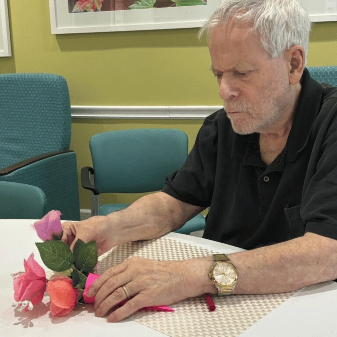 Resident of The Bristal Assisted Living at Bethpage arranging a bouquet for Valentine's Day