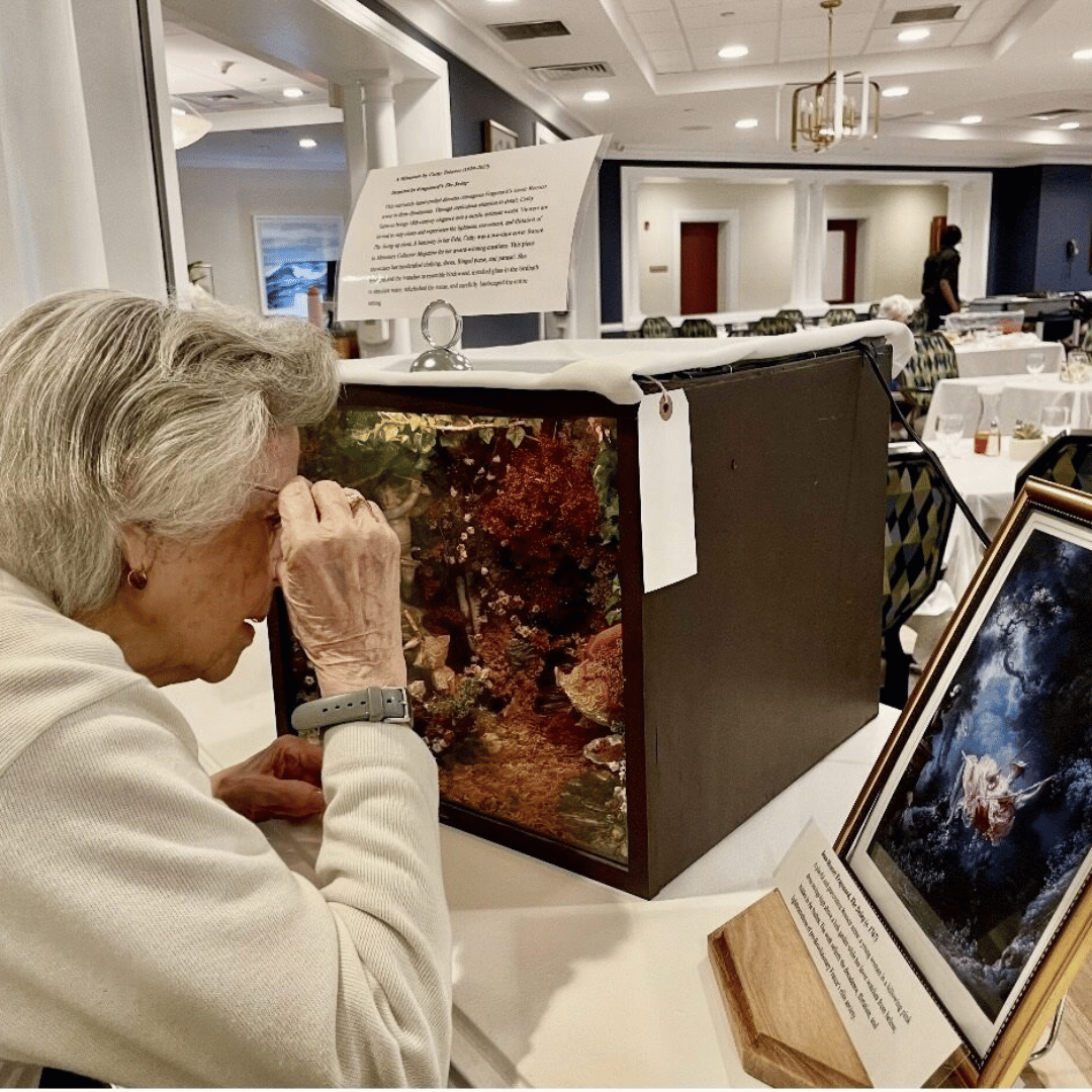 A resident of THe Bristal Assisted LIving at East Northport views a miniature on display at the Paris immersive event