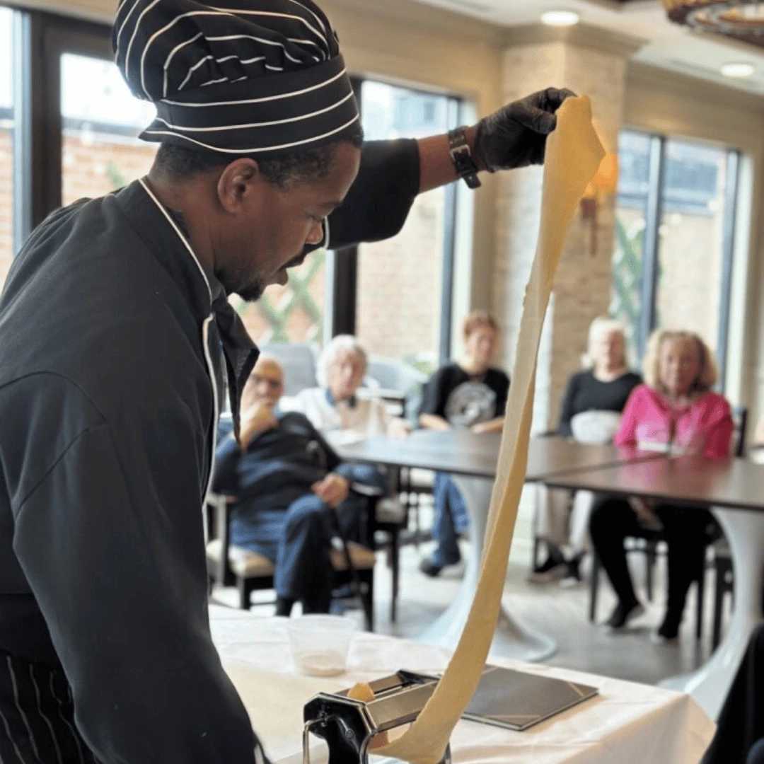 Chef Adrian rolls out pasta dough in a live demo