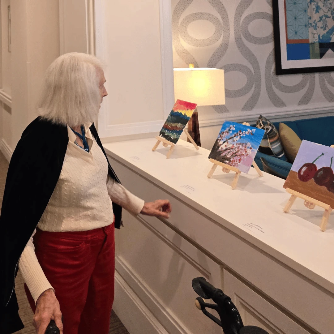 A resident pauses to admire the work of another at The Bristal Assisted Living Art Show