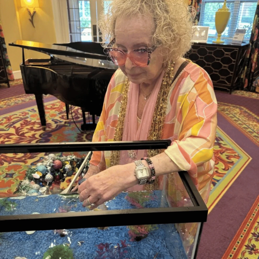 Resident at Lake Grove explores a touch tank during the immersive exhibit