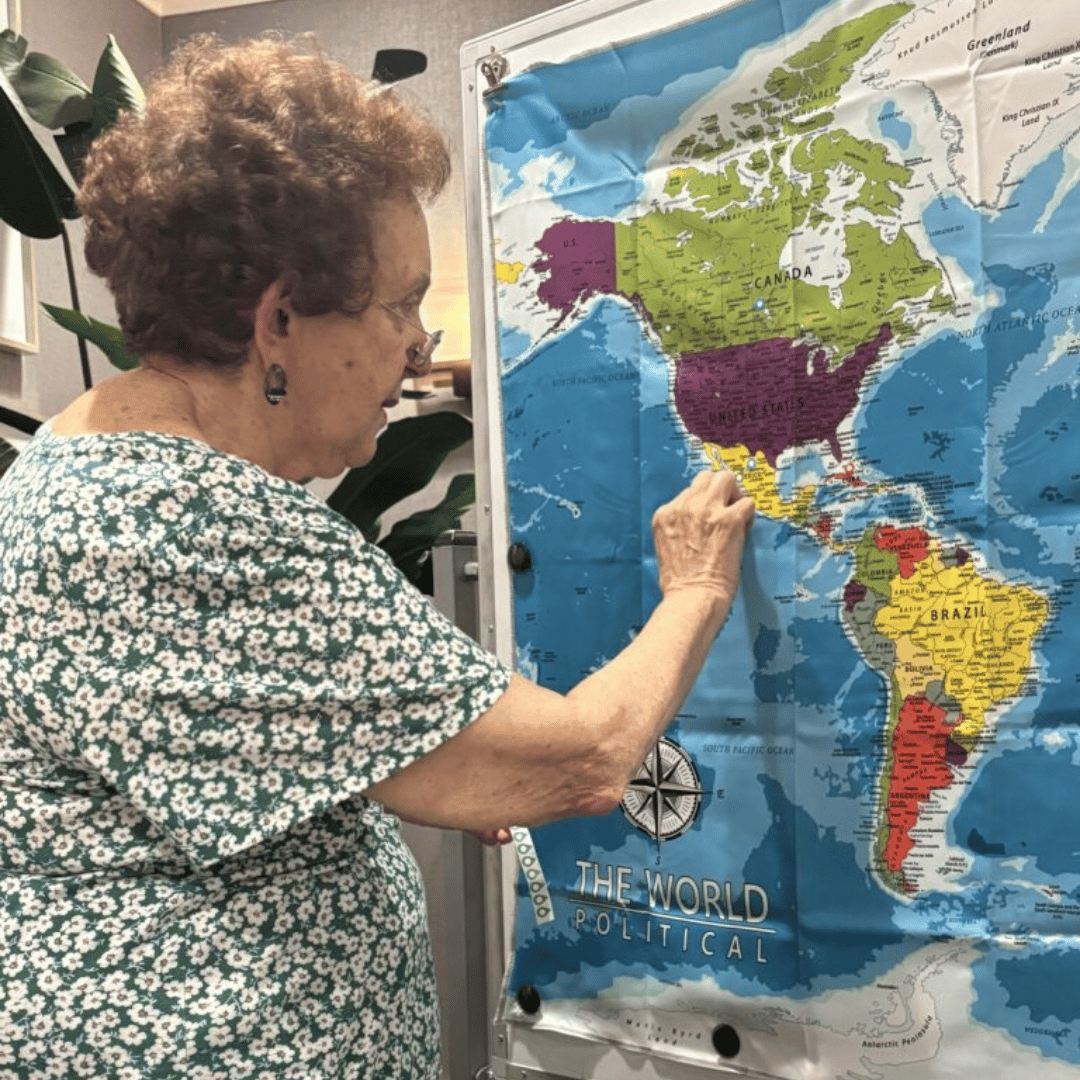 Resident at The Bristal at Bethpage points to a spot on the map where the immersive program will lead