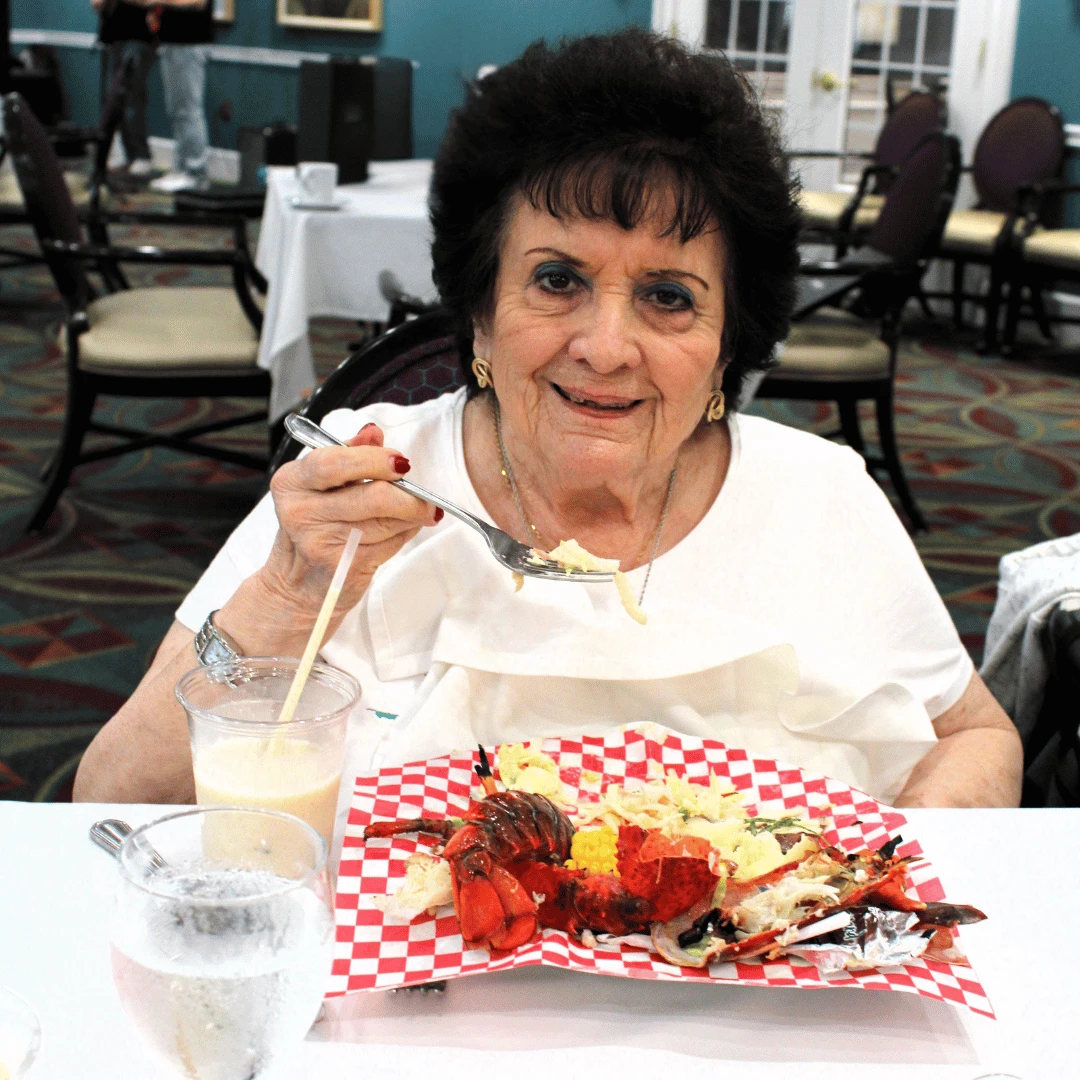 Resident at THe Bristal Assisted Living enjoys lobster at the annual white party