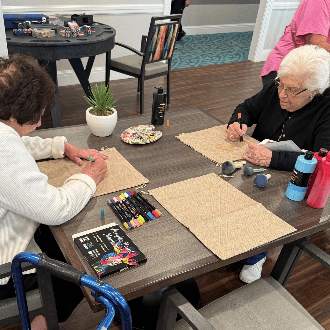 Residents at The Bristal at Sayville paint faces for their burlap scarecrows