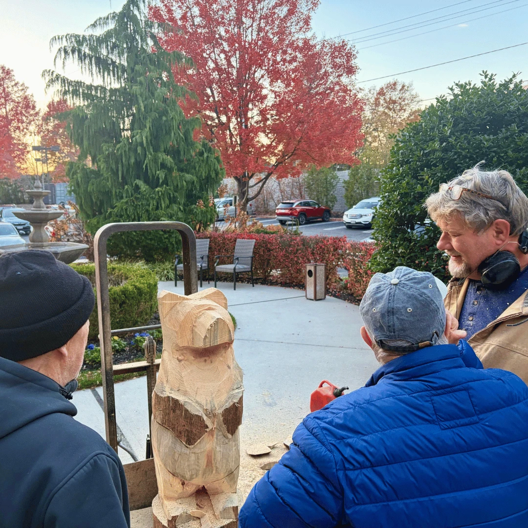 Residents admire the work of a woodcarver at The Bristal Assisted Living