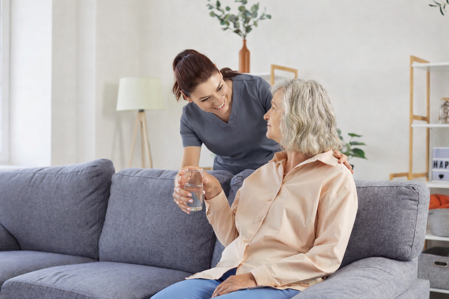 Team member of The Bristal handing a senior resident a glass of water
