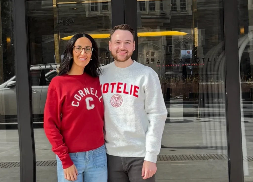 The Bristal Chief Operating Officer Amy Silva-Magalhaes stands with Corporate Director of Programming Innovation Evan Rossi, alumnus of Cornell, both donning Cornell attire