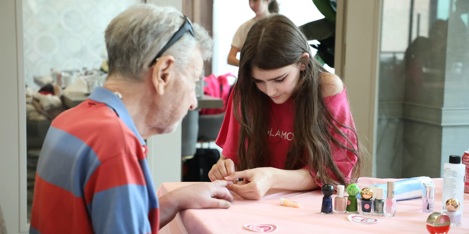 A resident of The Bristal at York Avenue has his nails manicured by GlamourGals volunteer