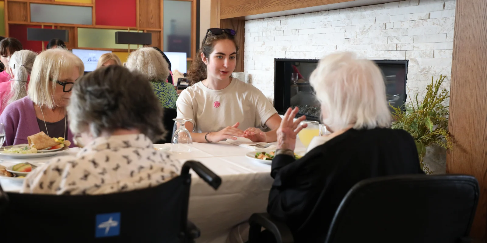 Lead GlamourGals Volunteer converses with several residents of The Bristal at York Avenue over lunch