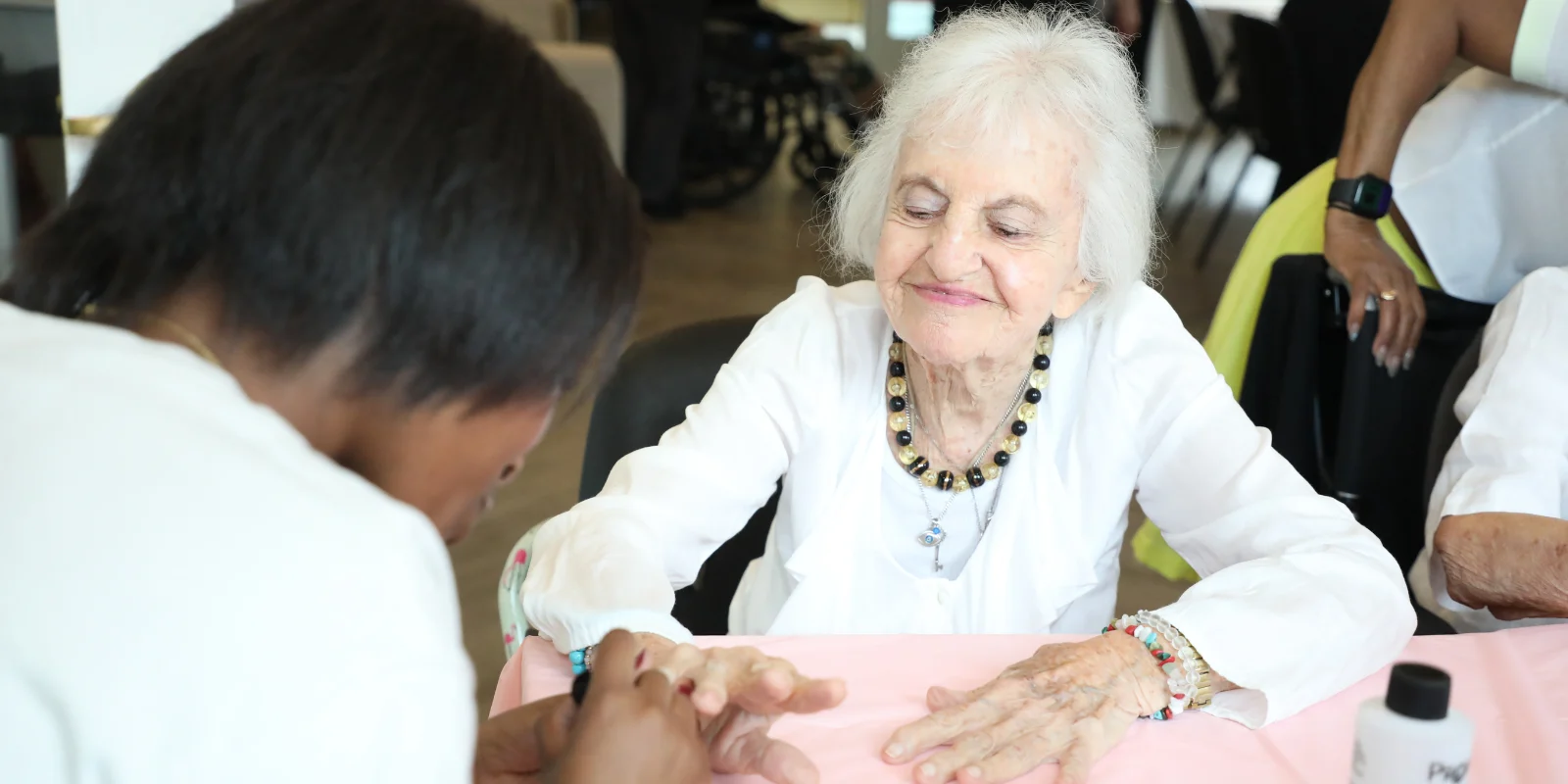 Resident at The Bristal at York Avenue smiling as she receives a manicure