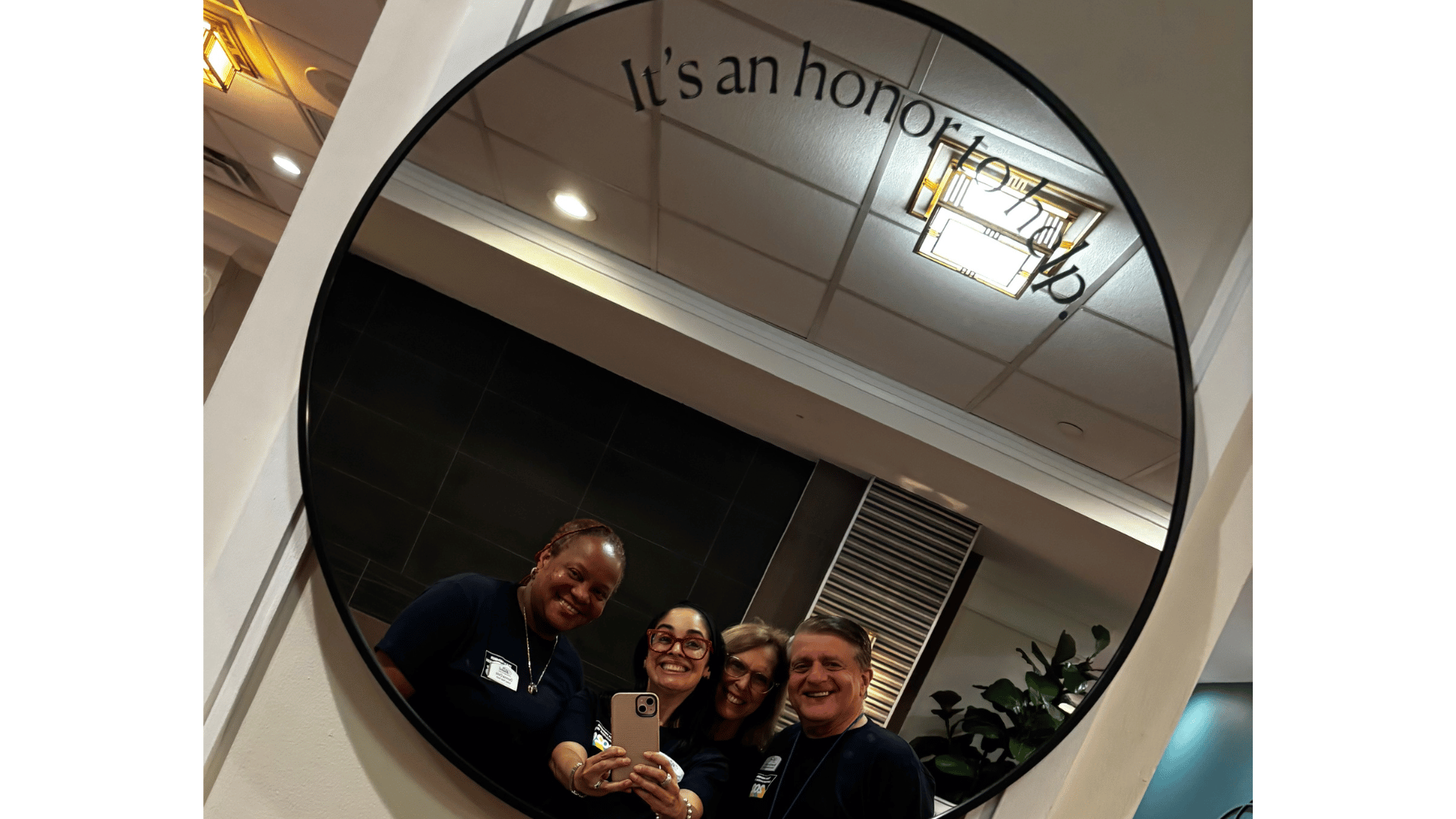 Team Member Appreciation Week at The Bristal at White Plains- Team members pose in front of a mirror with the tagline It's an Honor to Help