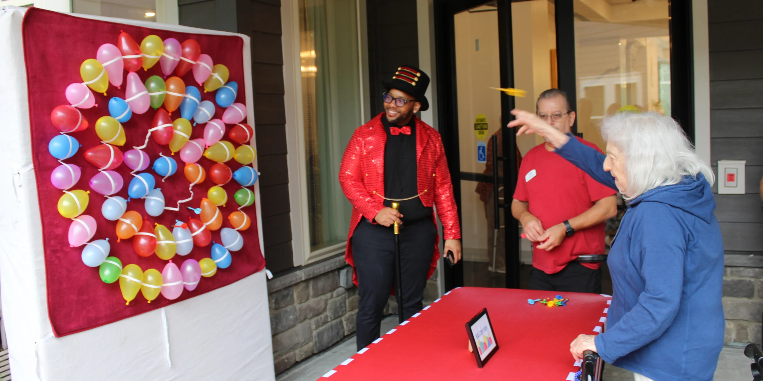 Grandparents Day at The Bristal at Waldwick - Resident plays a dart game at the carnival